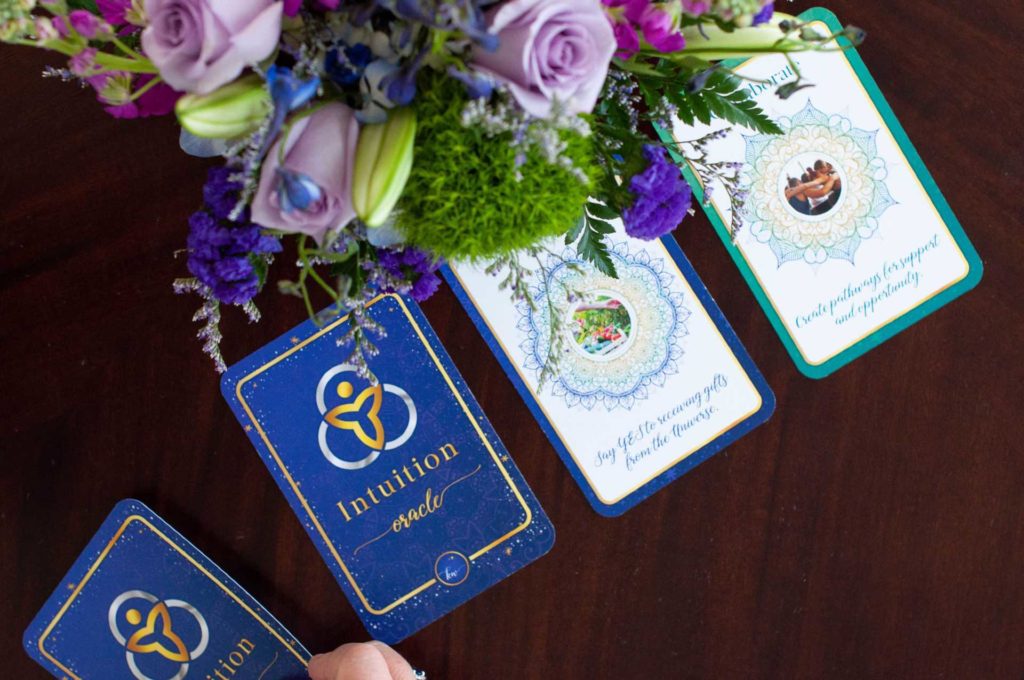 Intuition Oracle Cards on a table with beautiful flowers