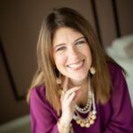 start here Brigette Barr wearing a magenta blouse and layered jewelry, featured in a client testimonial about her experience with Kim Woods’ intuitive business coaching.