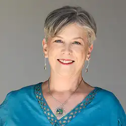 Kim Woods' client Kathy Mela in a teal blouse with plain background