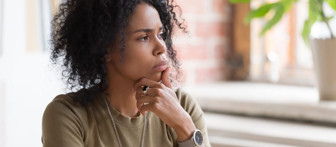 Thoughtful doubt African American businesswoman or student with hand under chin feeling uncertain, thinking about project or difficult task, manager pondering business strategy, planning, close up